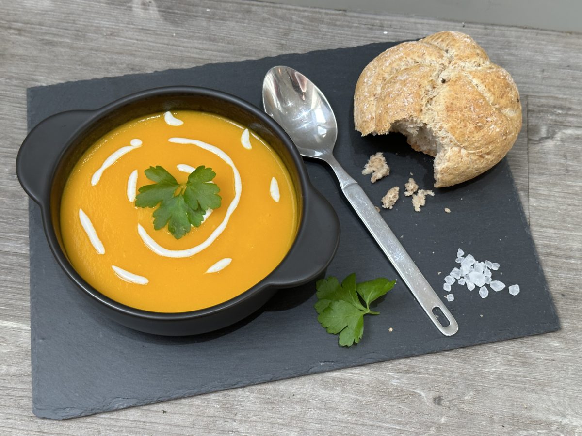 Carrot and ginger soup on grey wood