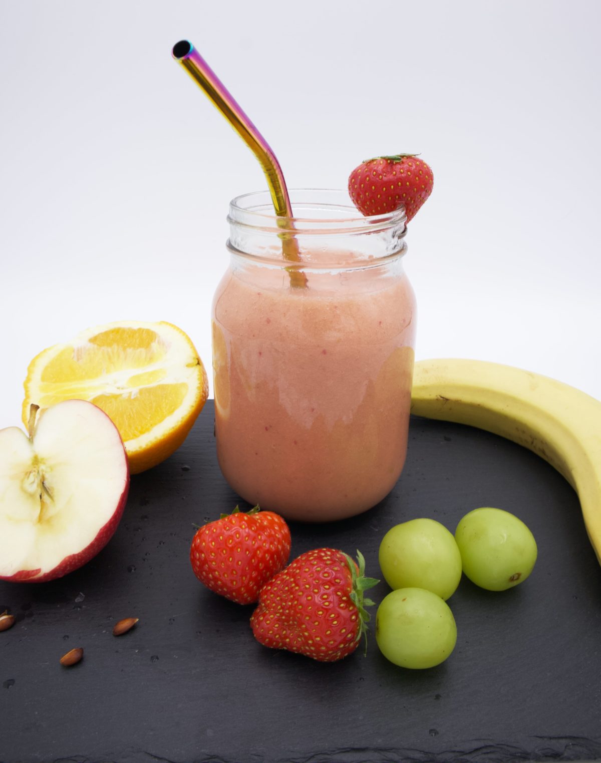 Glass full of Strawberry and Banana Smoothie with a Straw